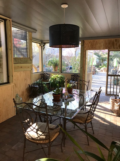 screened in porch with table and chairs