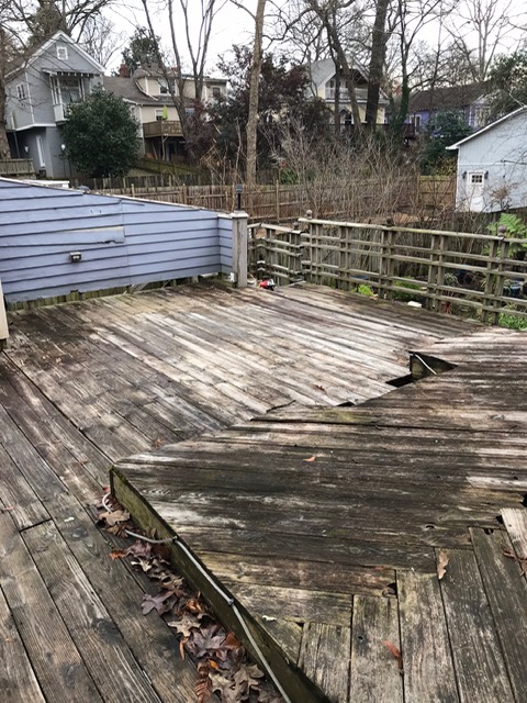 back of home with old wooden deck in disrepair