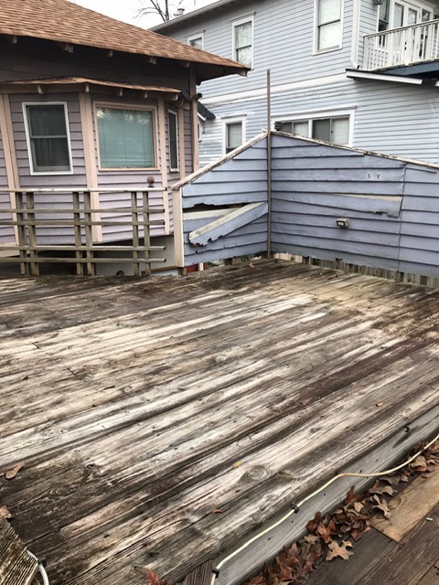 back of home with old wooden deck in disrepair